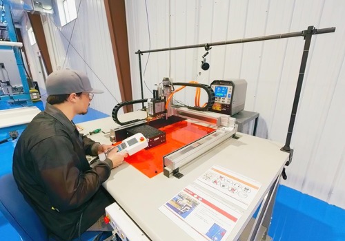 An engineering intern resistance welds on a prototype battery pack.